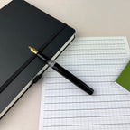Scrikss 419 Medium Nib Fountain Pen in Black GT on a squared sheet and diary