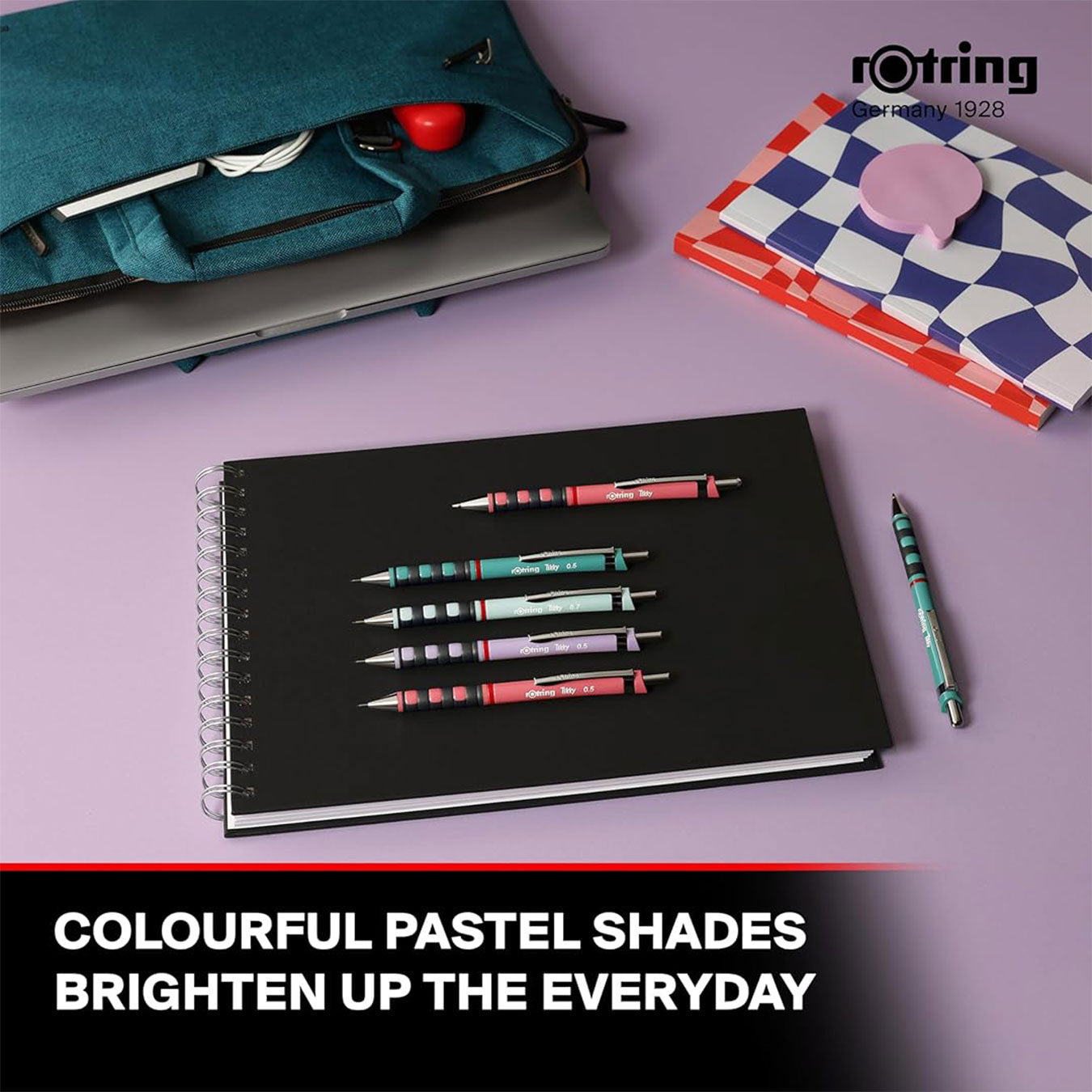 Notebook with pens on a purple surface, featuring Rotring branding.