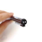 Close-up of a Rotring Tikky Graphic Fineliner with a 0.5mm tip, showing the pen's tip and a hand holding it.