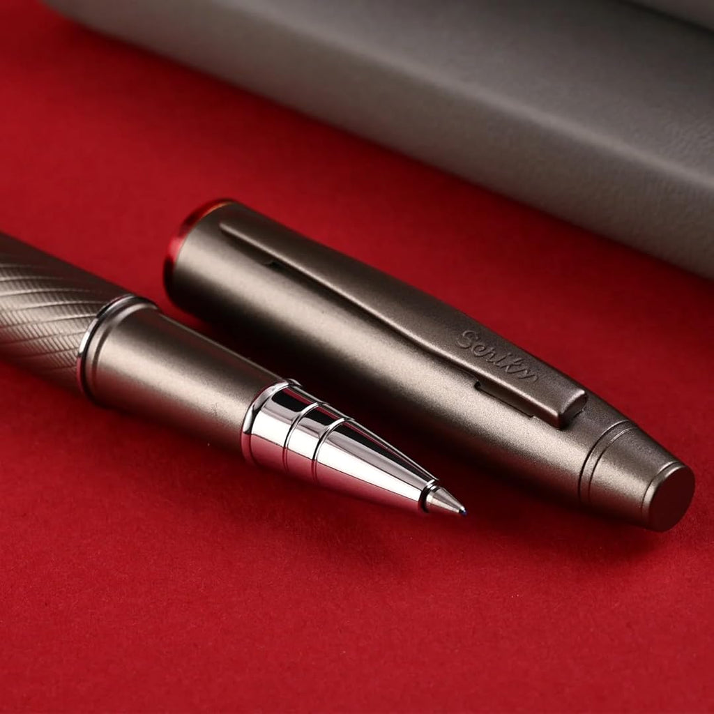 Scrikss Noble 35 Rollerball Pen in Matte Titanium on a red surface showing pen and pen cap side by side
