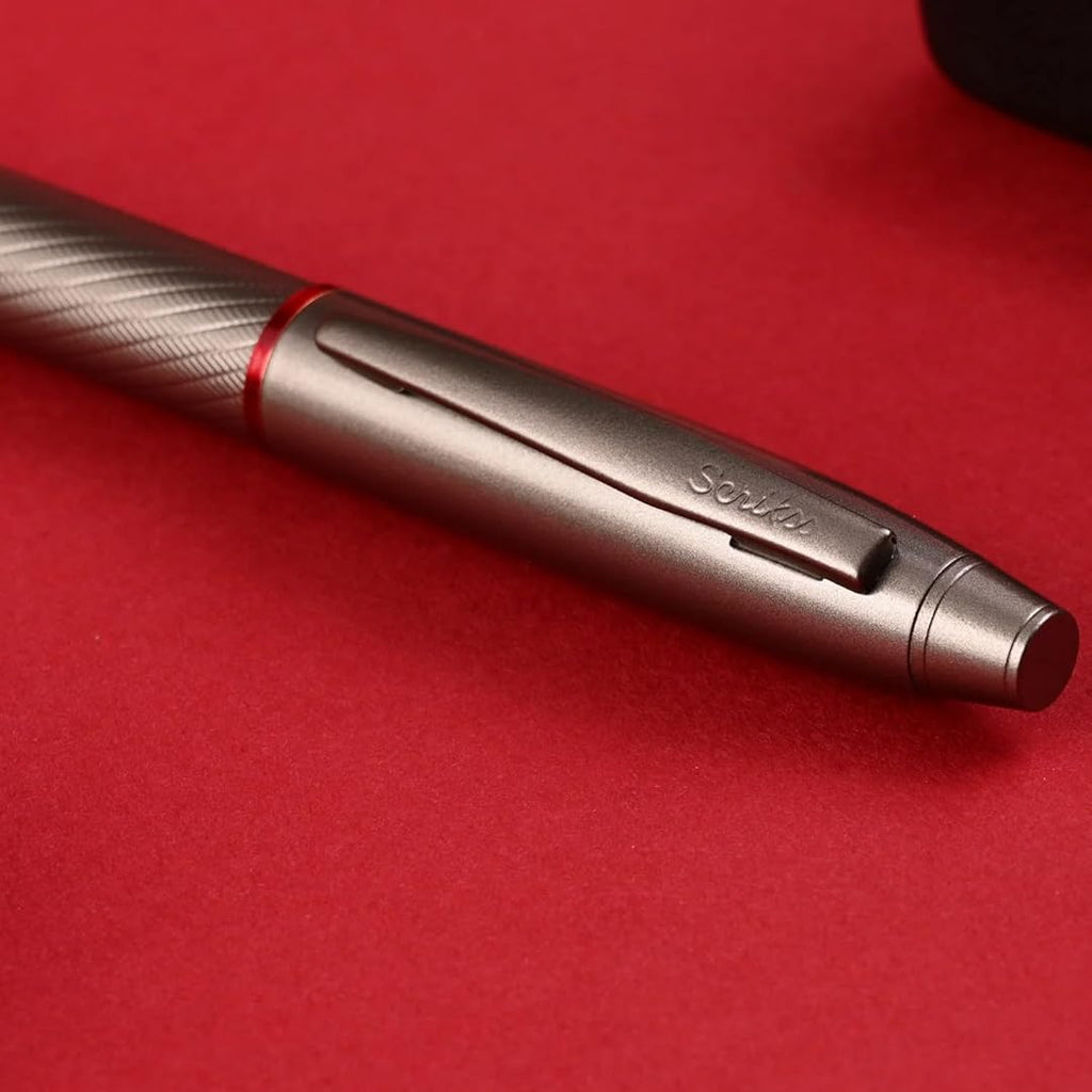 Scrikss Noble 35 Rollerball Pen - Matte Titanium on a red surface