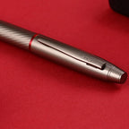 Scrikss Noble 35 Rollerball Pen - Matte Titanium on a red surface