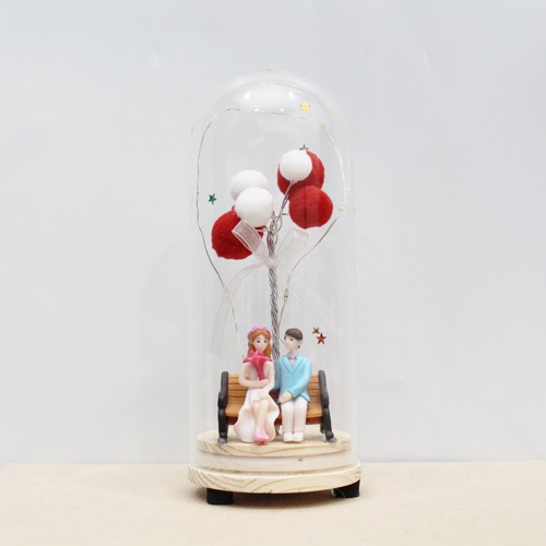 Couple Sitting On Bench With Balloons And Lights In Glass Shape Dome Showpiece